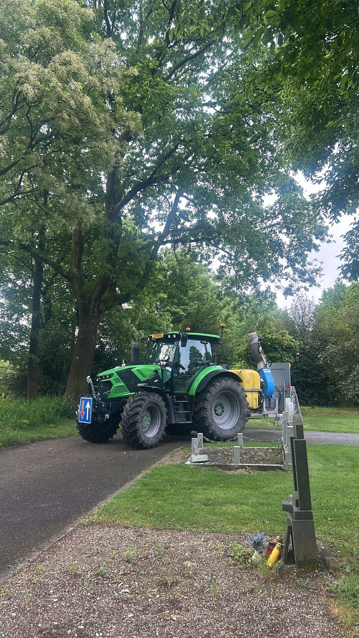 Tractor met watertank geeft water aan jonge bomen