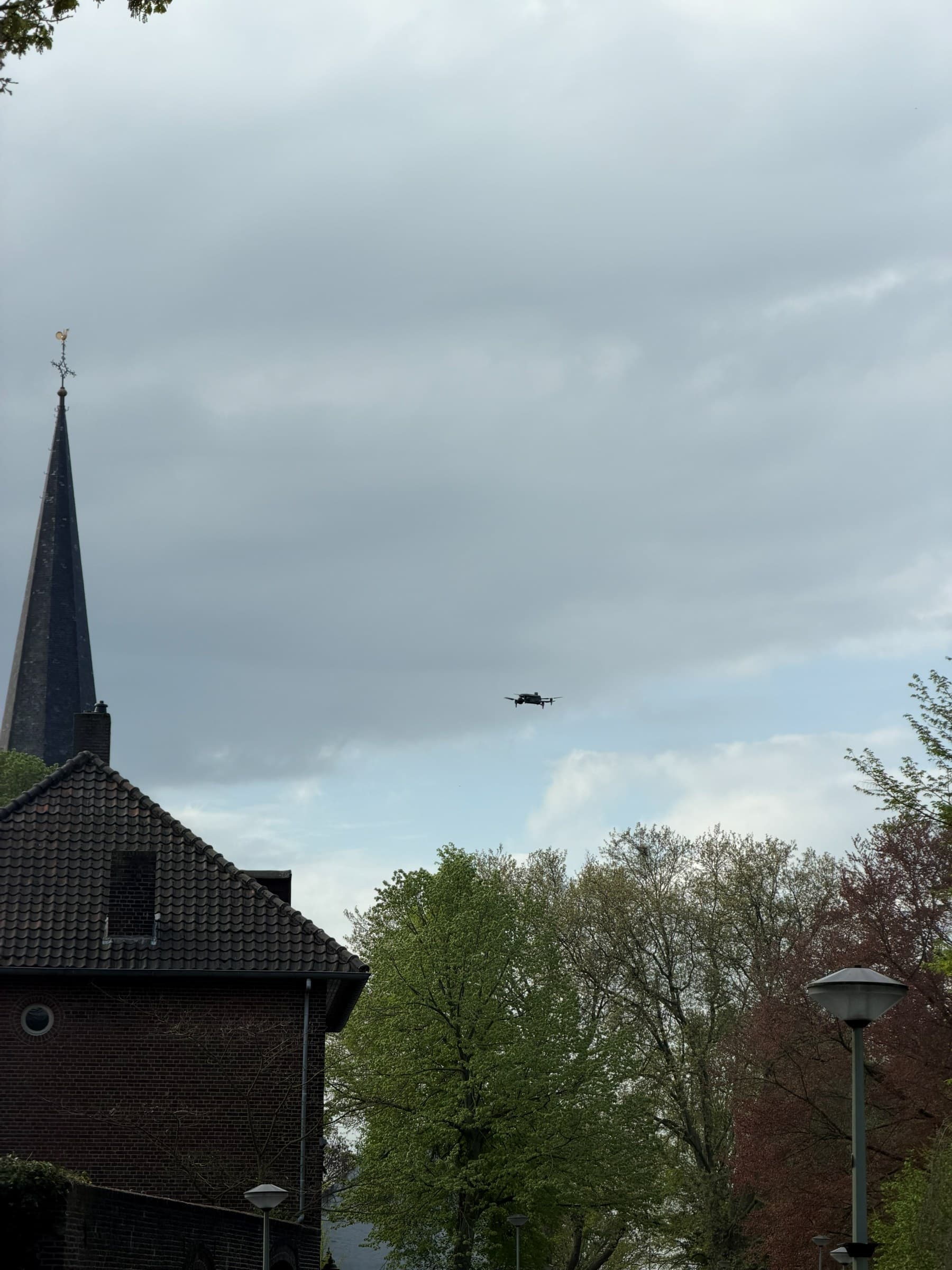 Drone-inspectie boven de bomen van een Limburgse dorpskern met kerktoren